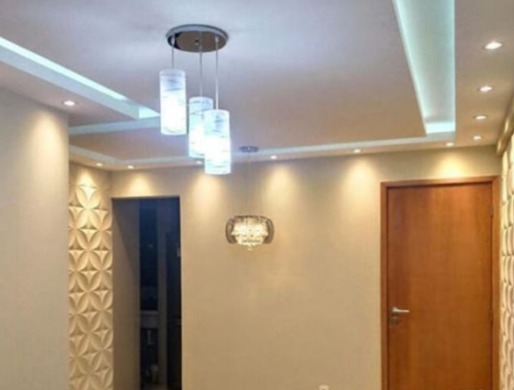 Sala com forro de gesso rebaixado, sanca com iluminação embutida e pendente de cristal